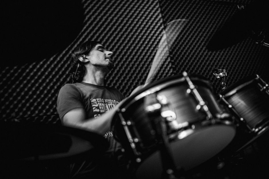Dynamic black and white image of a drummer in a music studio.