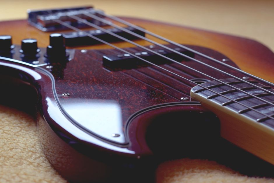 Detailed close-up of a tobacco burst jazz bass guitar showcasing strings and body details.