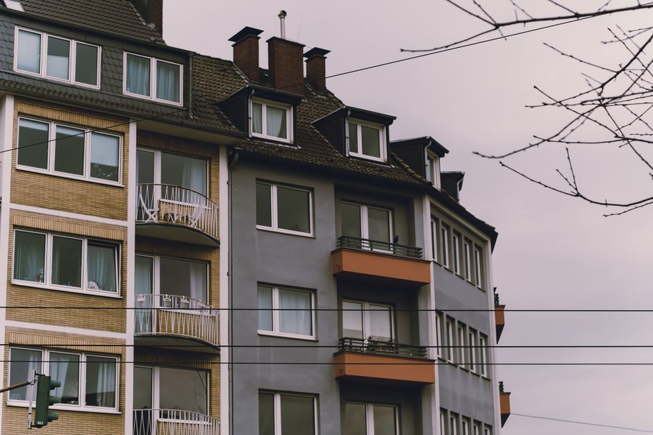European-style residential building exterior with balconies, under an overcast sky.