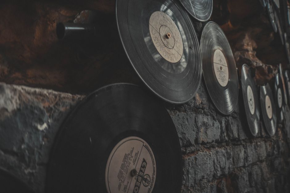 Close-up of vintage vinyl records displayed on a rustic brick wall, creating an artistic, nostalgic atmosphere.